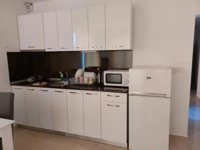a kitchen with white cabinets and a white refrigerator at SAPPHIRE in Sozopol