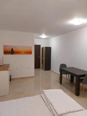 a living room with a table and a refrigerator at SAPPHIRE in Sozopol