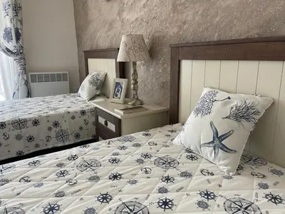 a bedroom with two beds and a table with a lamp at Sozopolis Cliffs Luxury Seaview Villa in Sozopol