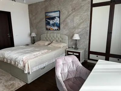 a bedroom with a bed and a table with a chair at Sozopolis Cliffs Luxury Seaview Villa in Sozopol