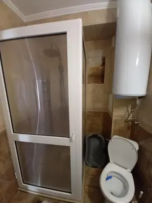 a bathroom with a toilet and a glass shower door at Salvia in Ravda