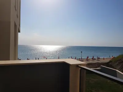 a view of the beach from the balcony of a building at Dolphin beach apart Obzor in Obzor