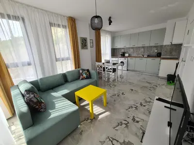 a living room with a green couch and a yellow table at Gold beach apart Obzor in Obzor