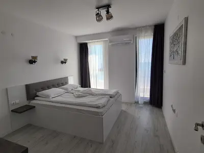 a bedroom with a bed and two windows at Cactus beach apart Obzor in Obzor