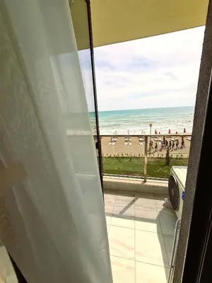 a room with a view of the beach from a balcony at Cactus beach apart Obzor in Obzor