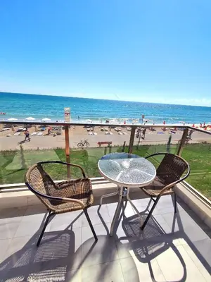 a table and chairs on a balcony with a view of the beach at Cactus beach apart Obzor in Obzor