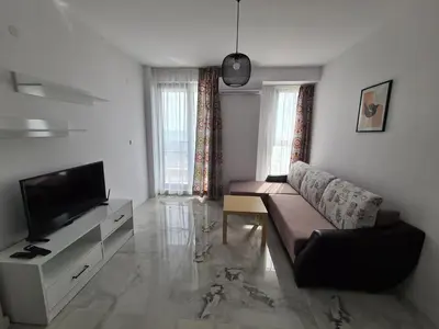 a living room with a couch and a flat screen tv at Cactus beach apart Obzor in Obzor