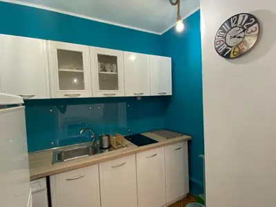 a kitchen with white cabinets and a clock on the wall at KALIA A16 Private One Bedroom Apartment in Sunny Beach