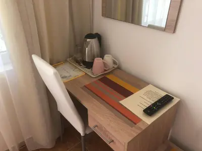 a wooden desk with a keyboard and a computer on it at Borko Guest House in Primorsko