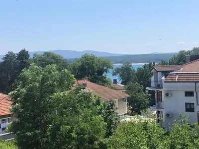 a group of houses with a lake in the background at Borko Guest House in Primorsko