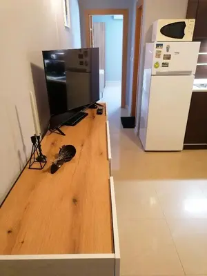 a flat screen tv sitting on top of a wooden floor at Casa do Farol - апартамент с басейн до плажа на къмпинг 