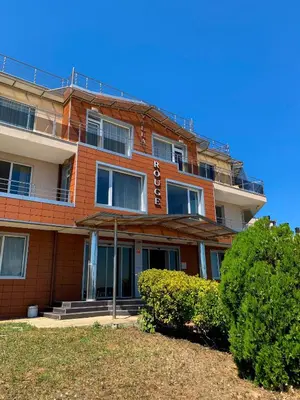 a large orange building with bushes in front of it at Villa Rouge - Apartment Victoria in Sozopol