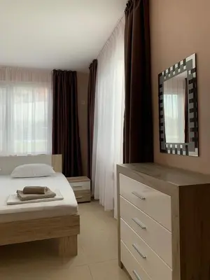 a bedroom with a bed and a dresser and a mirror at Villa Rouge - Apartment Victoria in Sozopol