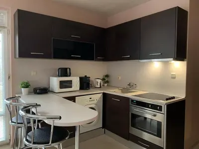 a kitchen with a table and chairs and a microwave at Villa Rouge - Apartment Victoria in Sozopol