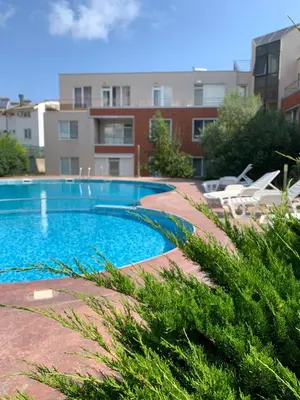 a swimming pool in front of a building at Villa Rouge - Apartment Victoria in Sozopol