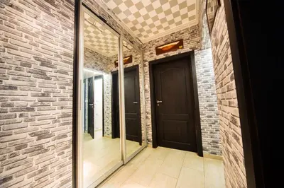 a hallway with a brick wall and a black door at Tsarigradska in Burgas City
