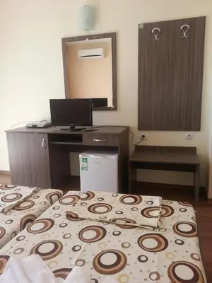 a bedroom with a bed and a desk and a mirror at Hotel Ray in Sozopol