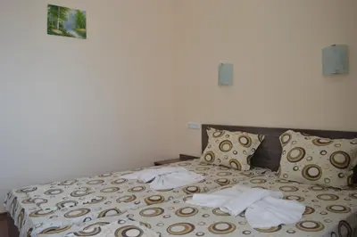 a bed in a room with two towels on it at Hotel Ray in Sozopol
