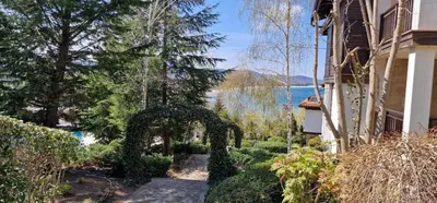 a garden with an archway next to a building at Eve Santa Marina Apartments - sea, pools, relax in Sozopol