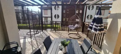 a balcony with a table and chairs and a flag at Eve Santa Marina Studios - sea, pools, relax in Sozopol