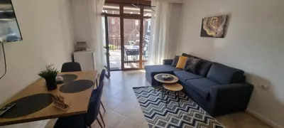 a living room with a blue couch and a table at Eve Santa Marina Studios - sea, pools, relax in Sozopol