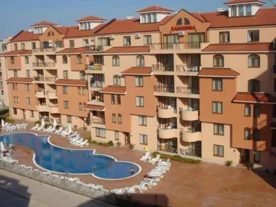 a large apartment building with a swimming pool and chairs at Holidays apartment Kassandra Sunny Beach in Sunny Beach