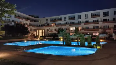 a building with two swimming pools in front of a building at Brisa Apartment in Burgas City