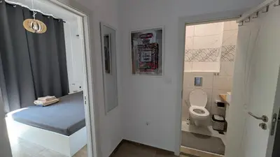 a small bathroom with a toilet and a sink at Brisa Apartment in Burgas City
