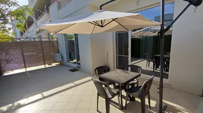 a table and chairs with an umbrella on a balcony at Brisa Apartment in Burgas City