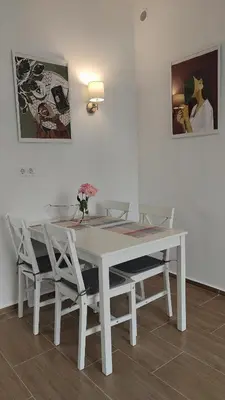 a white table and chairs with flowers on it at Brisa Apartment in Burgas City