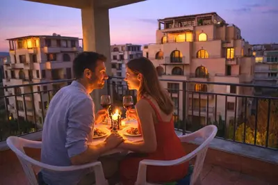 a man and woman sitting at a table with wine glasses at Sunset Dream Polo Resort in Sunny Beach