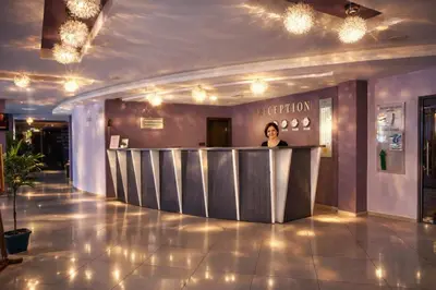 a woman standing at a reception desk in a lobby at Sunset Dream Polo Resort in Sunny Beach