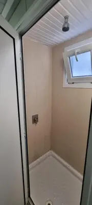 a bathroom with a shower and a window in it at Каравана Амалтея in Sozopol