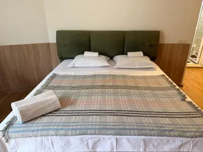 a large bed with two pillows on top of it at Студио ''Сарафово'' на първа линия in Burgas City