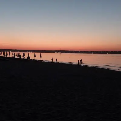 a group of people walking on the beach at sunset at Sozopoly studio in Sozopol