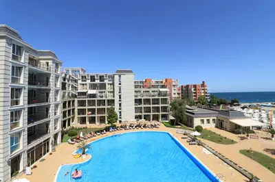 an overhead view of a swimming pool with buildings and the ocean at Първа линия Апартаменти in Pomorie