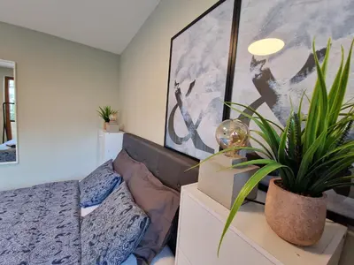 a bedroom with a bed and potted plants at Marsselis Luxe Port Apartment in Varna City