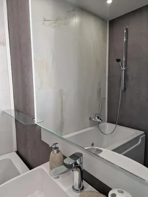 a bathroom with a sink and a mirror and a tub at Marsselis Luxe Port Apartment in Varna City