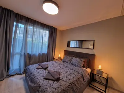 a bedroom with a bed and a large window at Marsselis Luxe Port Apartment in Varna City