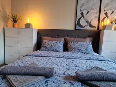 a bedroom with a bed with a blue comforter and pillows at Marsselis Luxe Port Apartment in Varna City