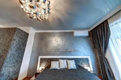 a bedroom with a bed and a chandelier at Luxe Apartment Olymp in Sveti Vlas in Sveti Vlas