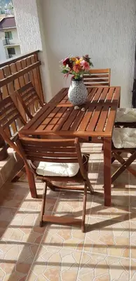 a wooden table and bench with a vase of flowers on it at Luxe Apartment Olymp in Sveti Vlas in Sveti Vlas