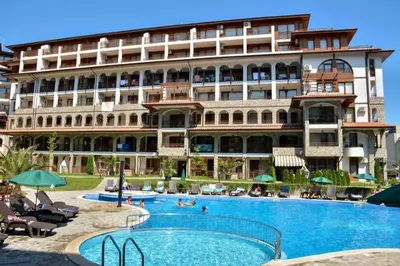 a hotel with a swimming pool in front of a building at Luxe Apartment Olymp in Sveti Vlas in Sveti Vlas