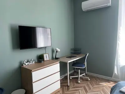 a bedroom with a desk and a tv on a wall at Las Brisas Garden Apartment in Burgas City