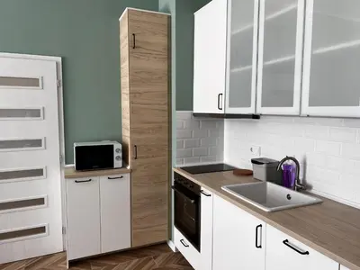 a kitchen with white cabinets and a sink and a microwave at Las Brisas Garden Apartment in Burgas City