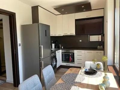 a kitchen with a dining table and a refrigerator at Studio Rêve in Burgas City