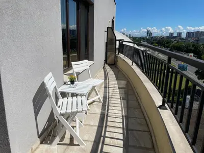 a balcony with two white chairs and a table at Studio Rêve in Burgas City