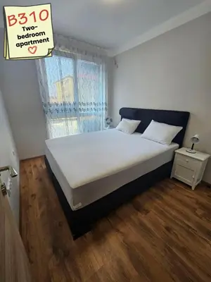a bedroom with a large bed with a wooden floor at Apartments Vilma&Villiam in Ravda