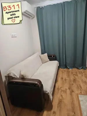 a couch in a room with a blue curtain at Apartments Vilma&Villiam in Ravda