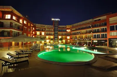 a swimming pool in front of a building at night at Heaven Lux Apartments in Sunny Beach
